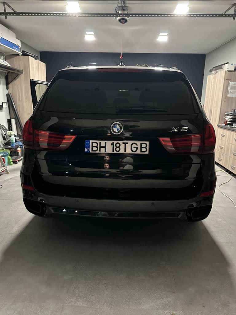 BMW X5 negru cu faruri și caroserie pregătite